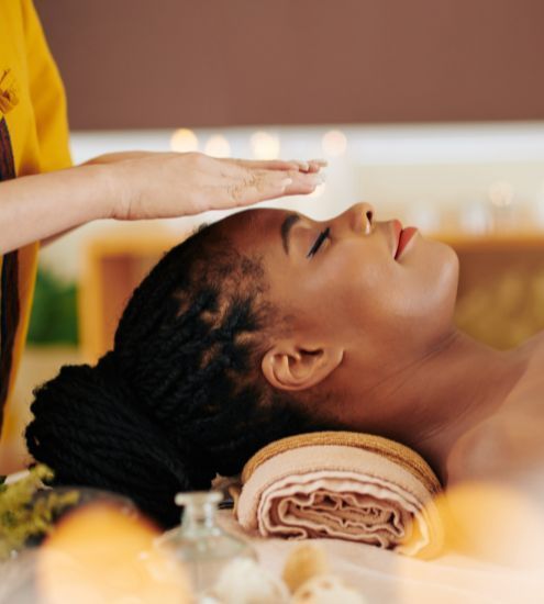 A woman is getting a massage at a spa with her eyes closed.