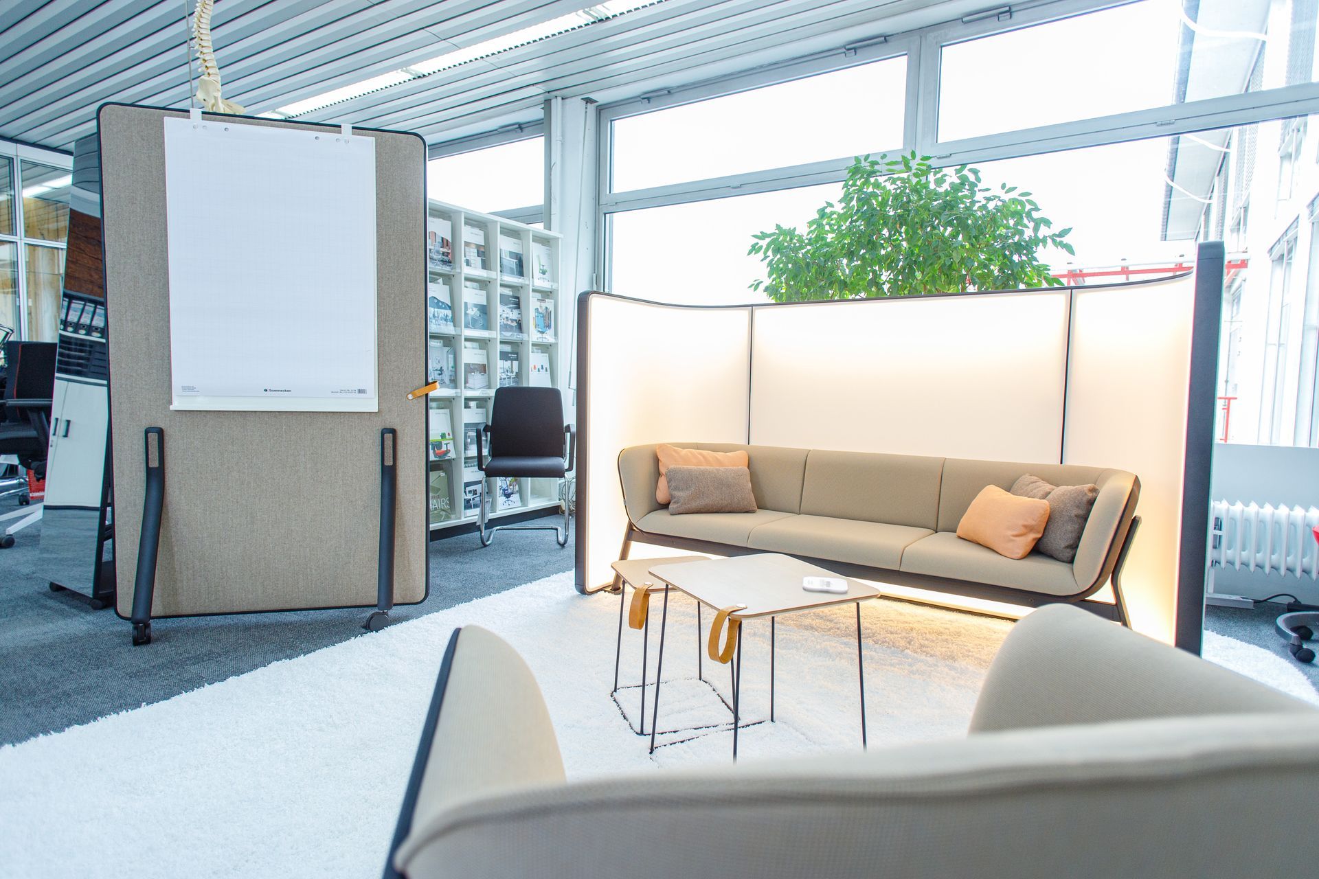 Offene Lounge mit Sofaelementen und Whiteboard – moderne Bürogestaltung. Ausstellung Wiepa in Wiesbaden