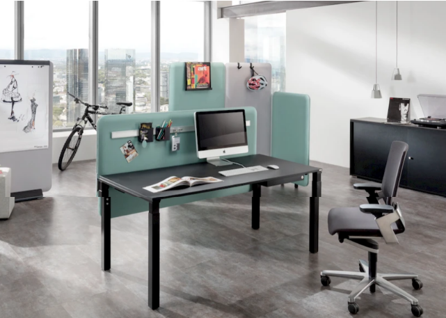 Helles Büro mit Schreibtischen und akustisch wirksamen Trennwänden für konzentriertes Arbeiten
