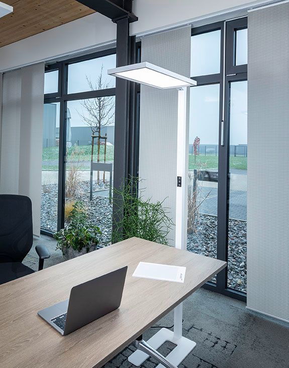 Moderner Besprechungsbereich mit großen Fenstern, Tageslicht und eleganter Tischplatte

