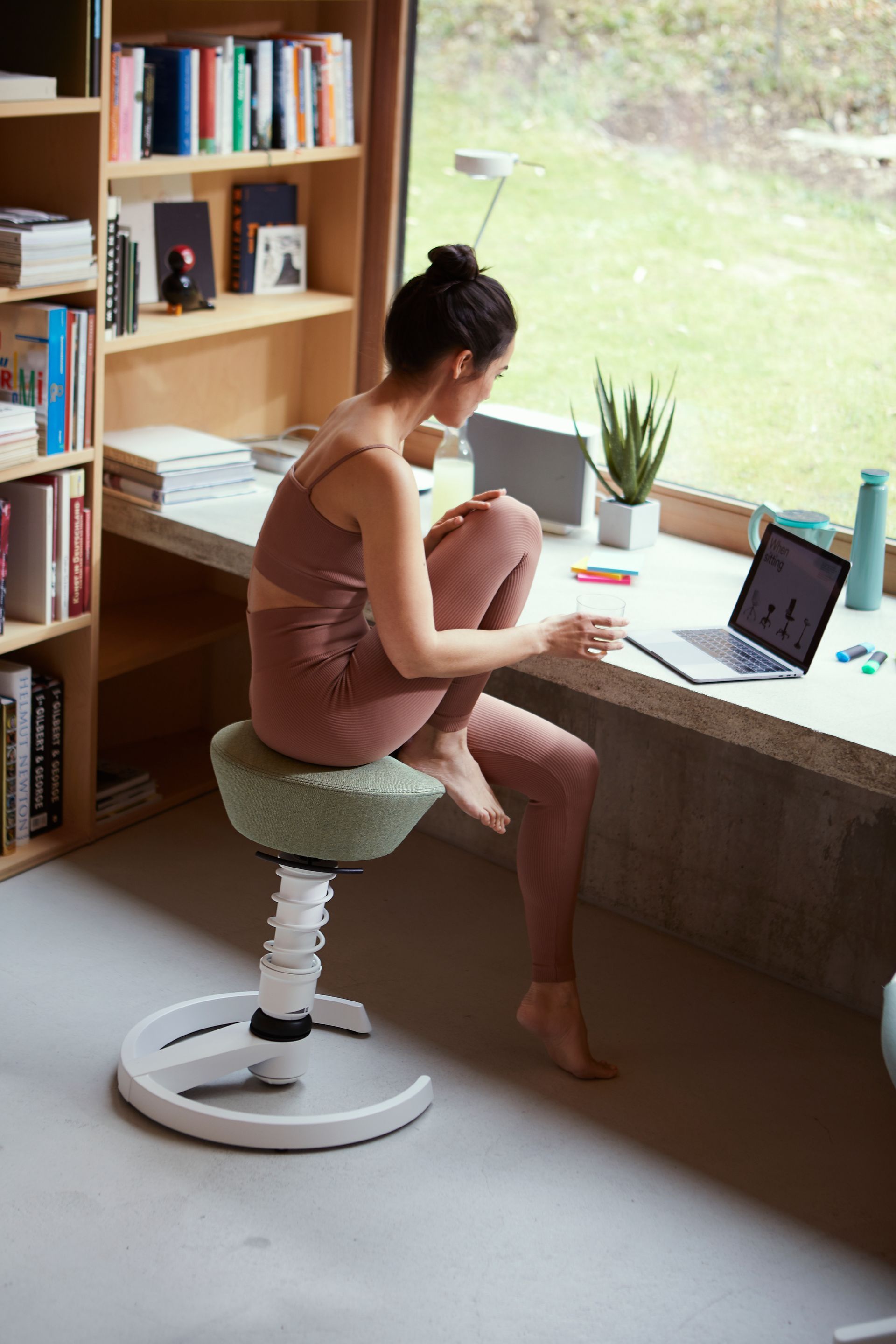 Frau arbeitet am Laptop auf ergonomischem Swopper-Hocker – entspannt & fokussiert
