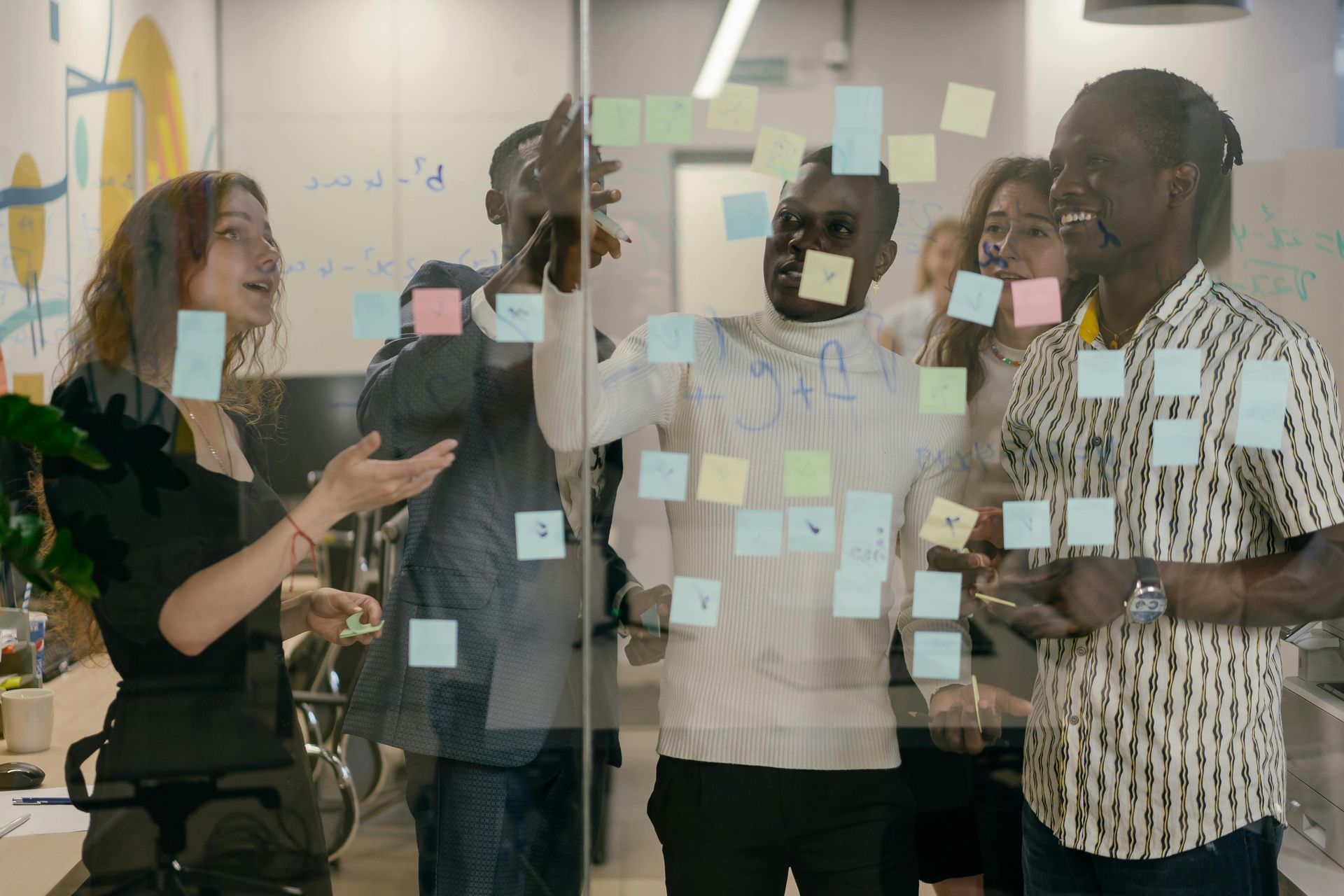 Vier Menschen die ein Meeting halten mit Post Its.