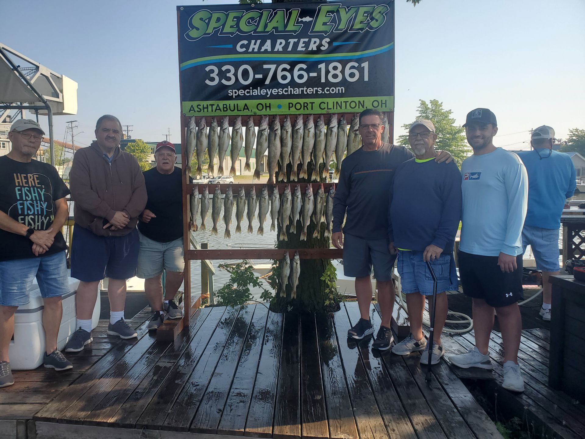 A group of men are posing for a picture in front of a sign for special eyes charters.