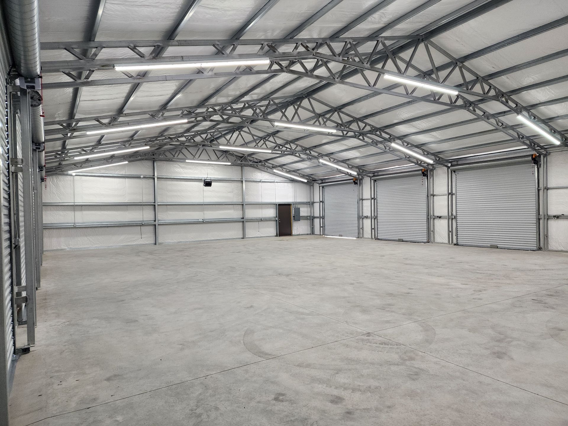 A large empty warehouse with a concrete floor and a metal roof.