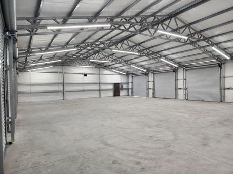A large empty warehouse with a concrete floor and a metal roof.