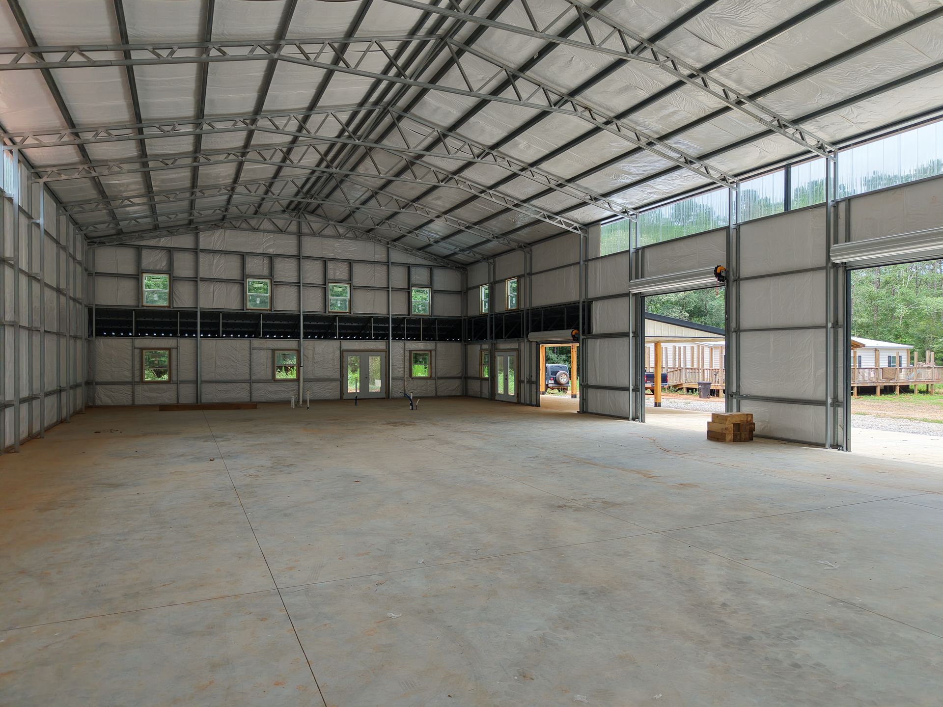 A large empty warehouse with a lot of windows and doors.
