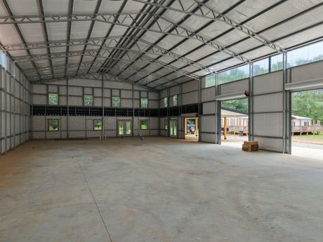 A large empty warehouse with a lot of windows and doors.