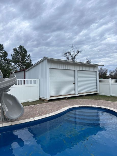 white pool house sitting next to a pool