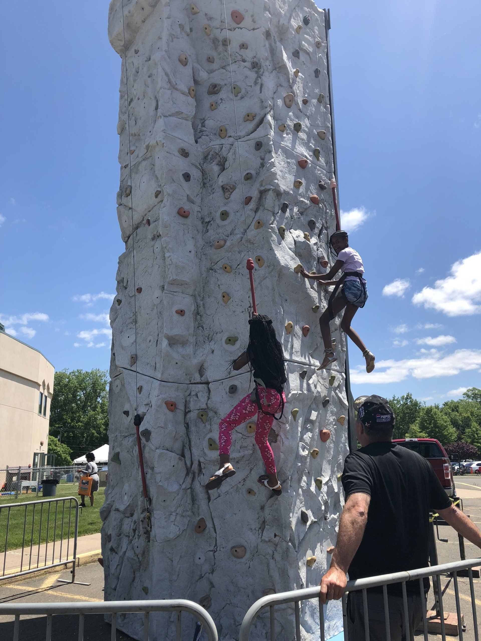 Adult Assisting the Two Girls Climbing — Chicopee, MA — Cliffhangers Portable Rock Climbing Wall