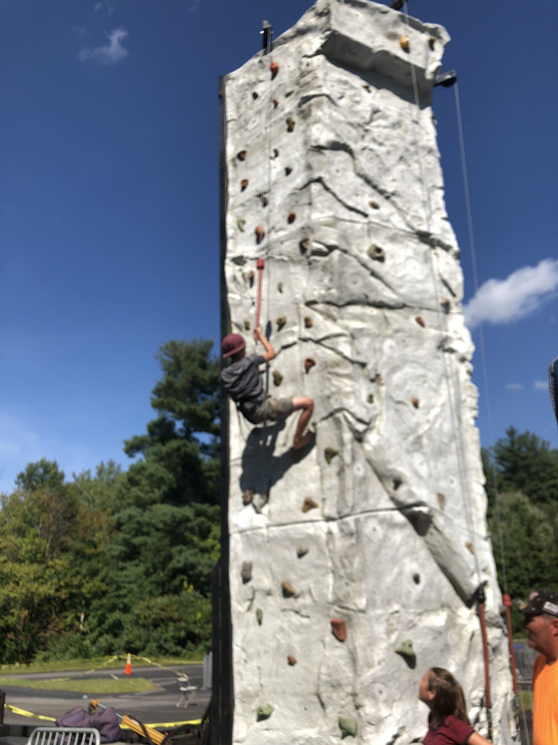 Boy Climbing While Adults Below Assist — Chicopee, MA — Cliffhangers Portable Rock Climbing Wall