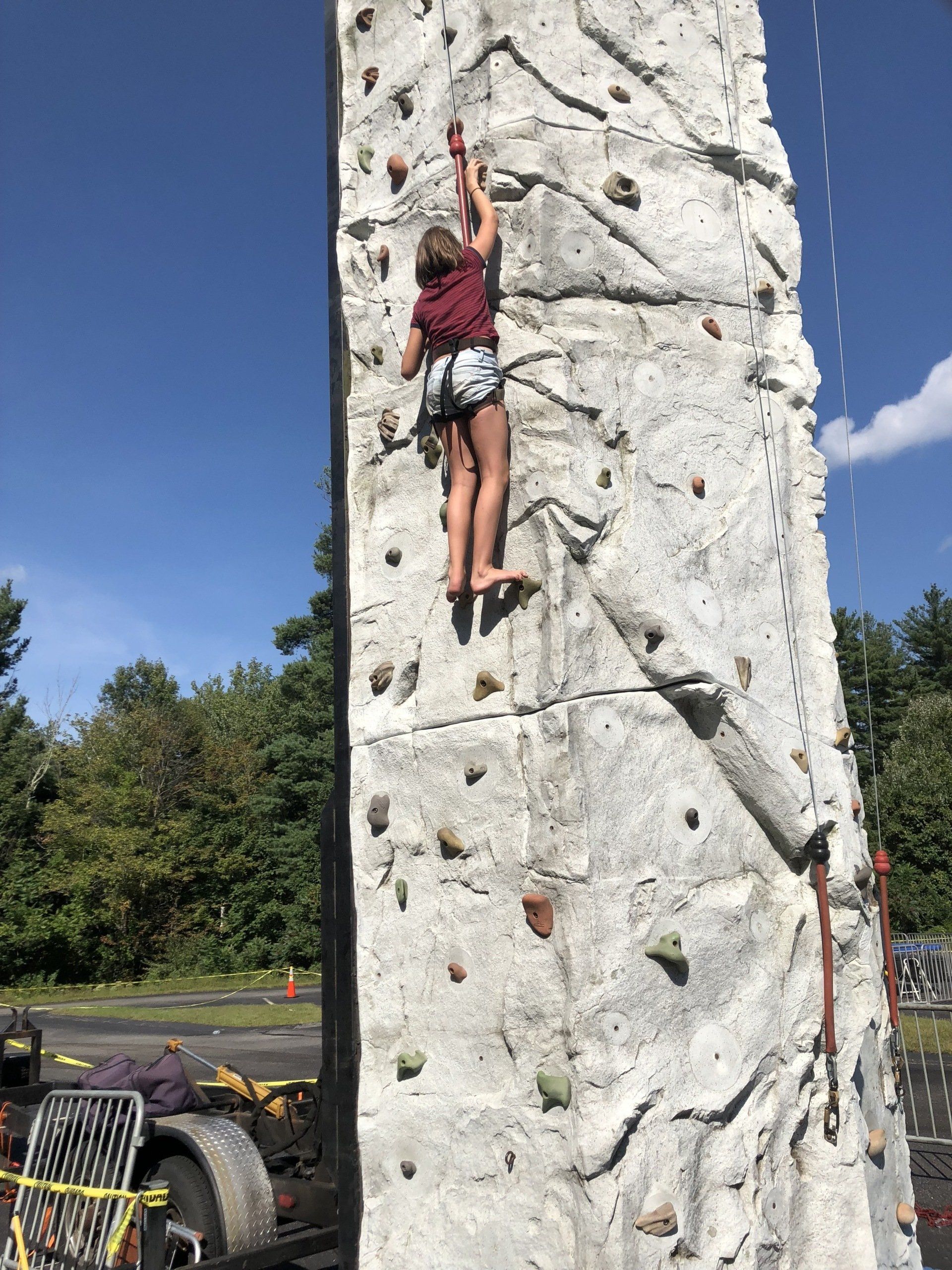 Girl Reaching the Top of The Rock Wall — Chicopee, MA — Cliffhangers Portable Rock Climbing Wall