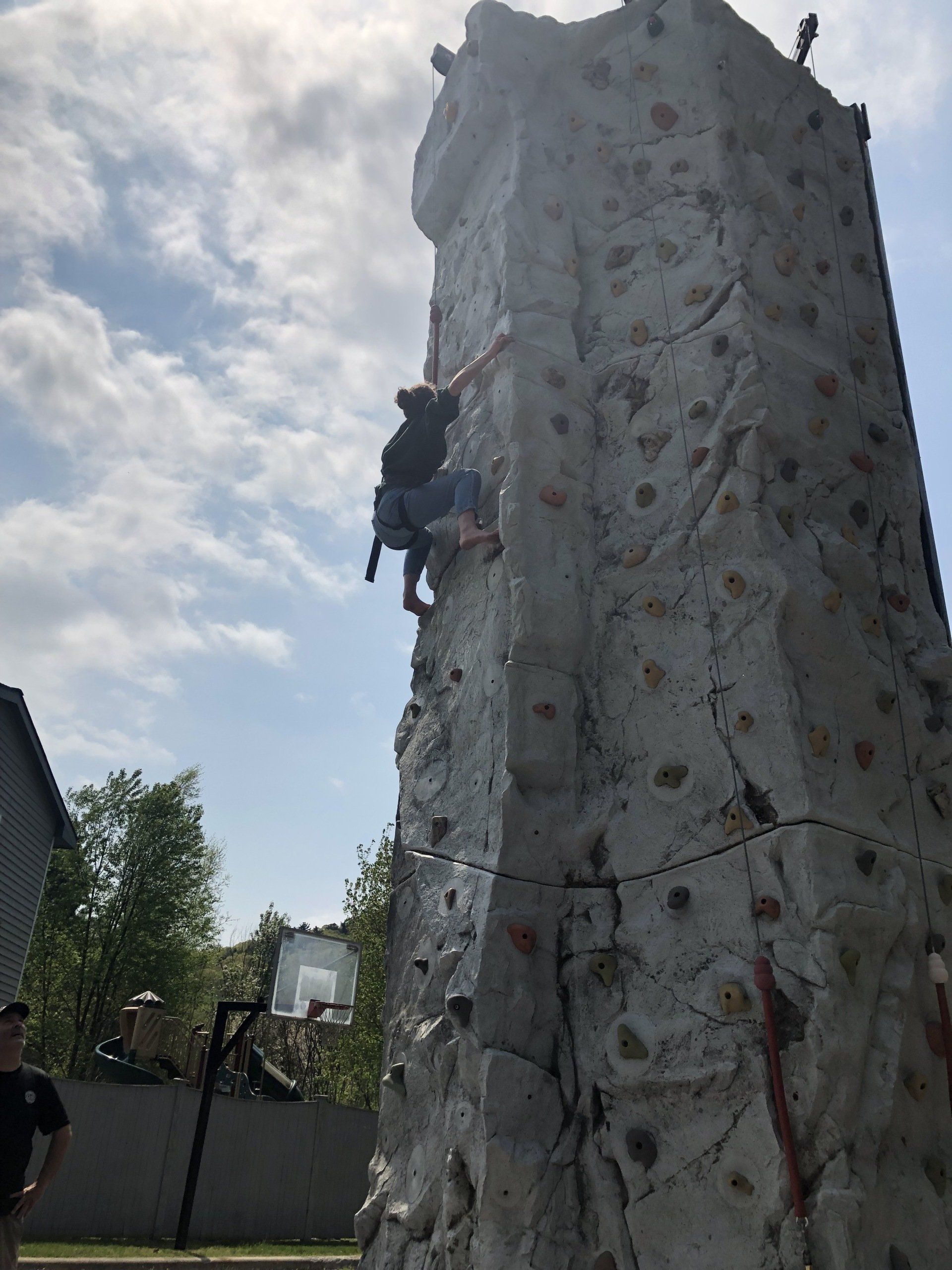 Woman Climbing While Adult Assist — Chicopee, MA — Cliffhangers Portable Rock Climbing Wall