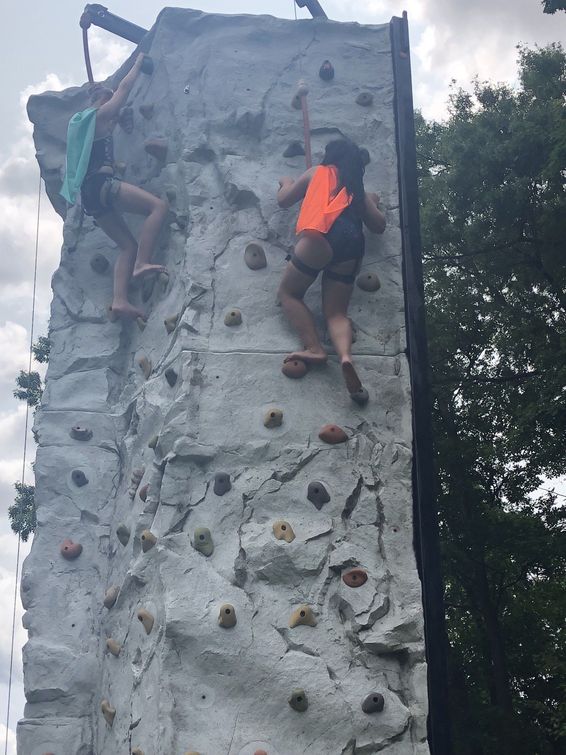 Women Reaching the Top of The Rock Wall Climbing — Chicopee, MA — Cliffhangers Portable Rock Climbing Wall