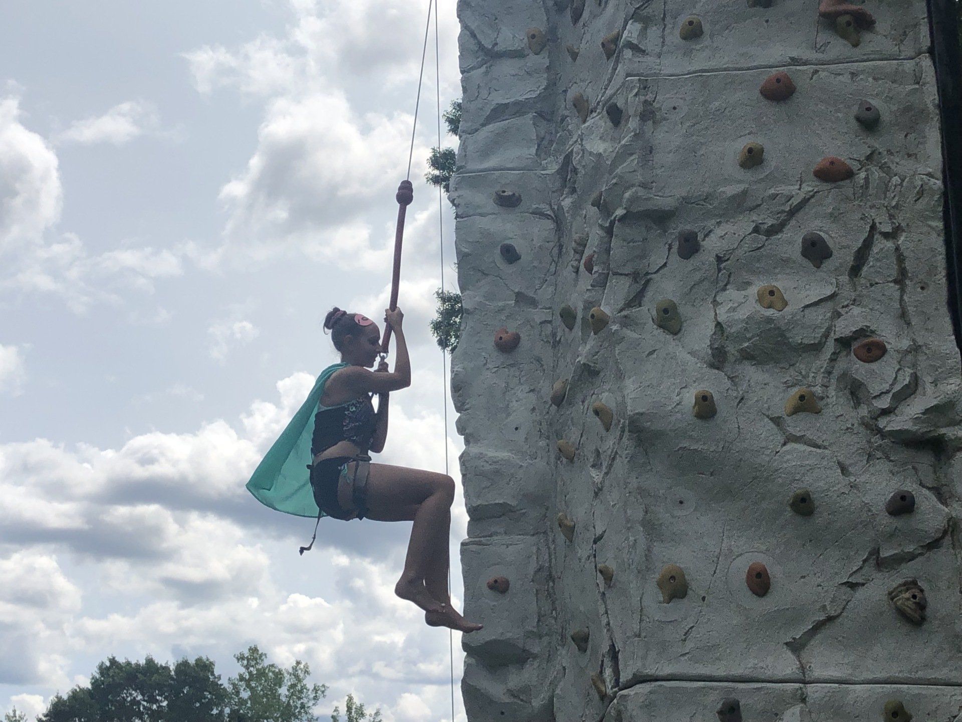Woman Climbing Against The Sky Background — Chicopee, MA — Cliffhangers Portable Rock Climbing Wall