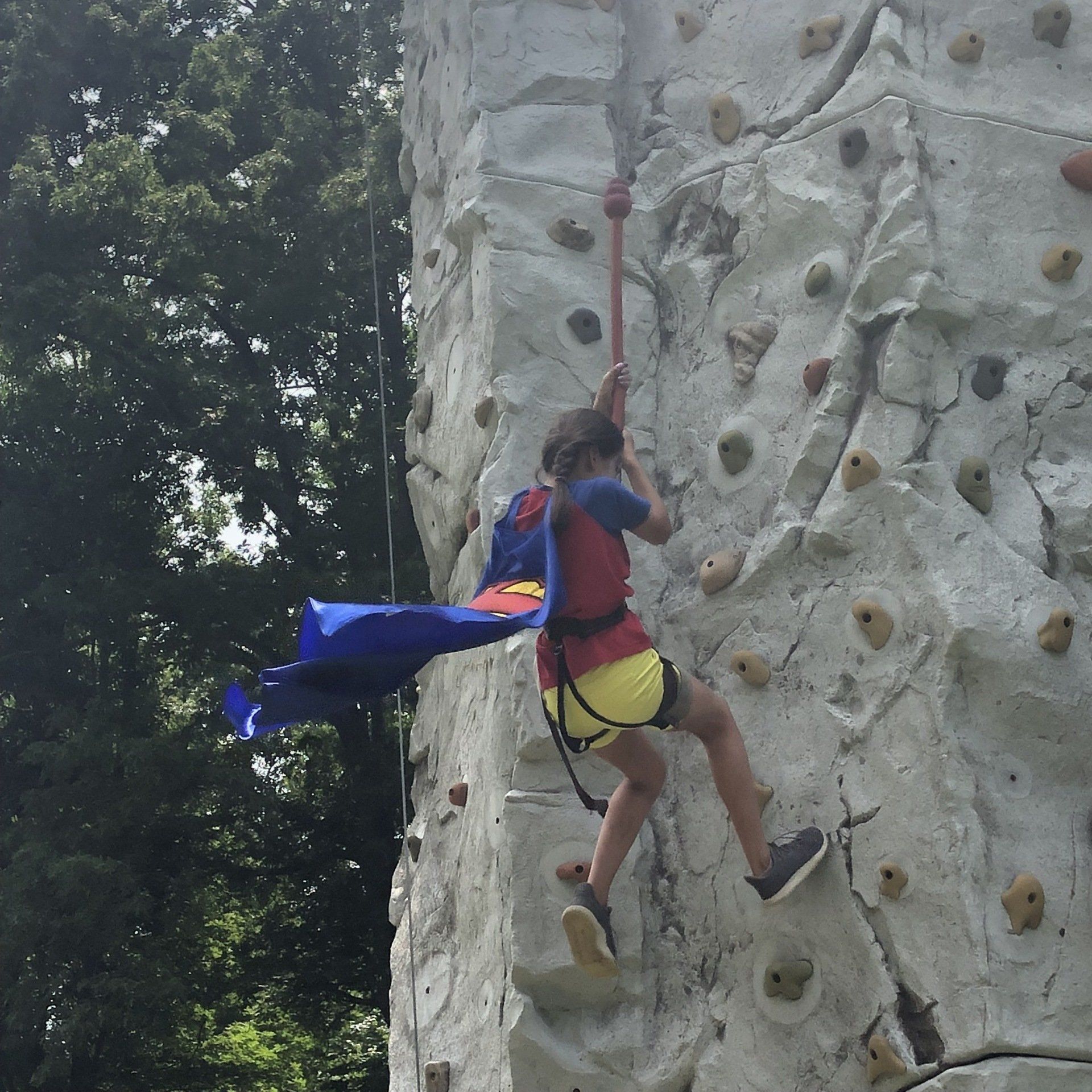 Girl Climbing With Superman Cape — Chicopee, MA — Cliffhangers Portable Rock Climbing Wall