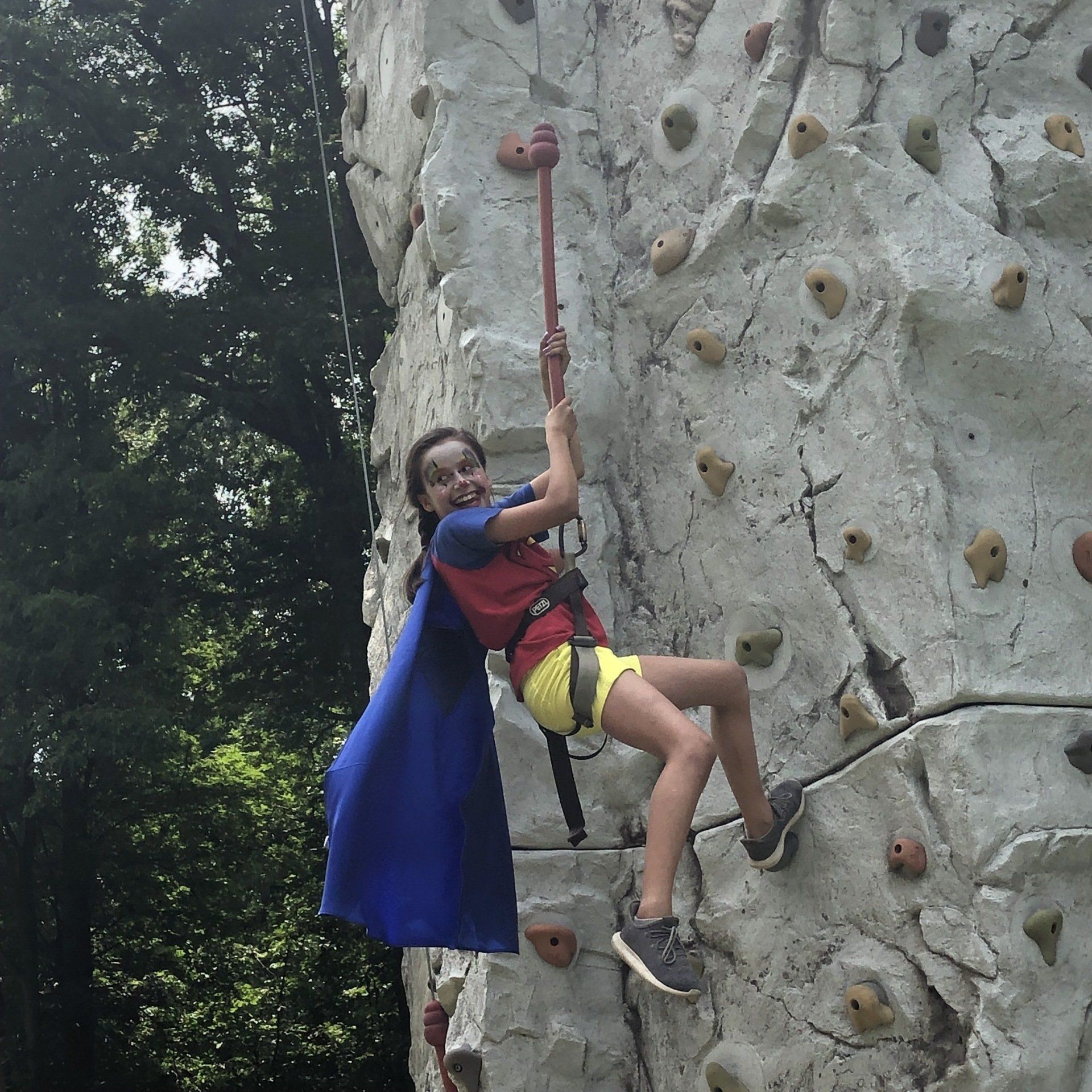 Girl Wearing Characters And Smile While Climbing — Chicopee, MA — Cliffhangers Portable Rock Climbing Wall