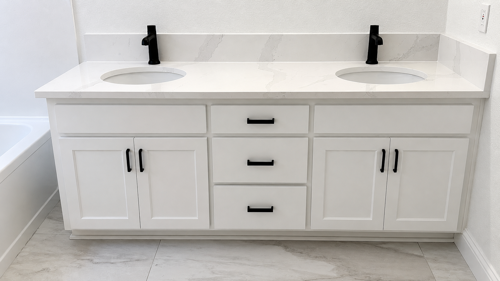 Elegant white bathroom with freestanding tub, glass shower, double sinks, and window.