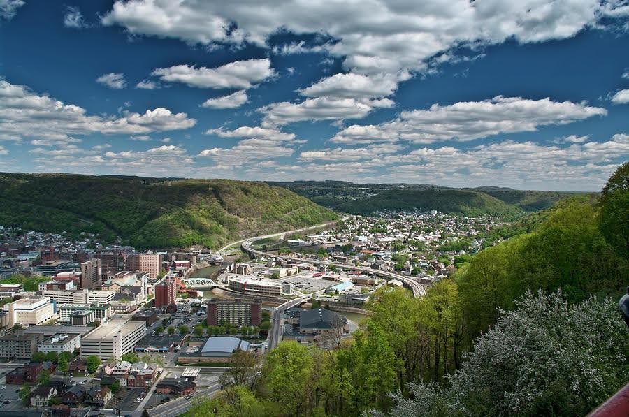 An aerial view of a city surrounded by trees and mountains
