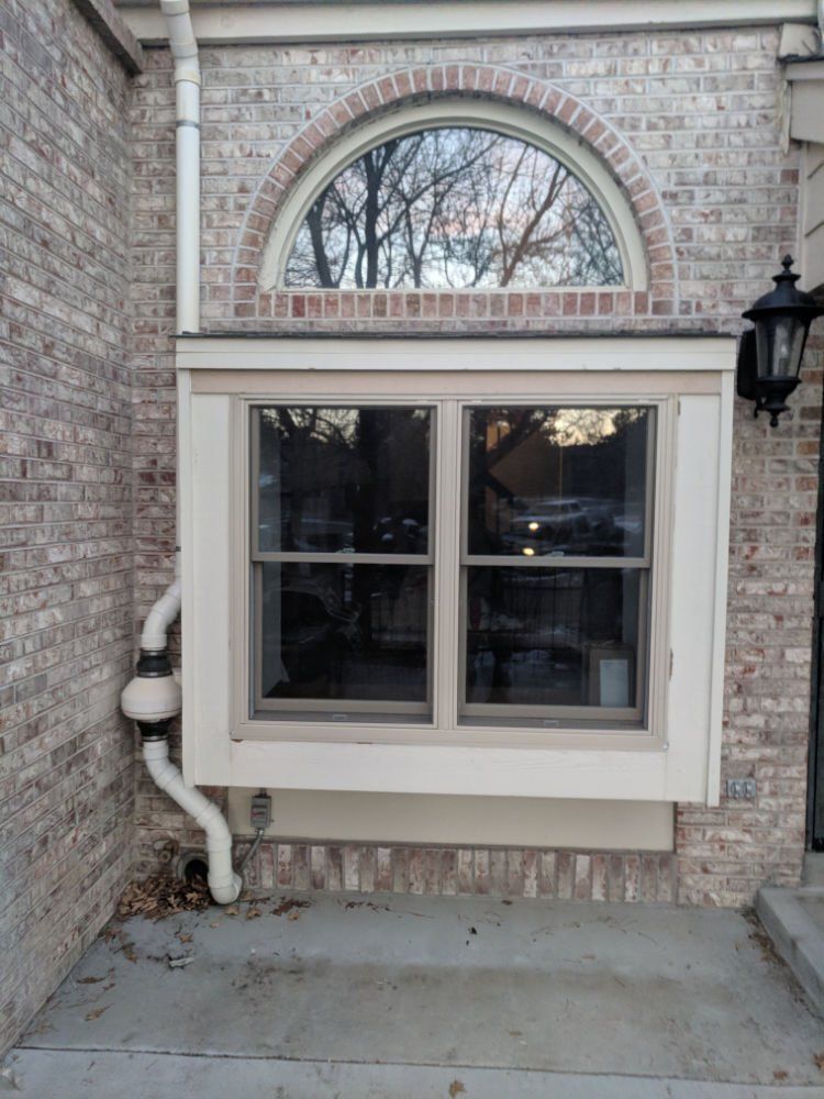 A brick building with a window and a drain pipe