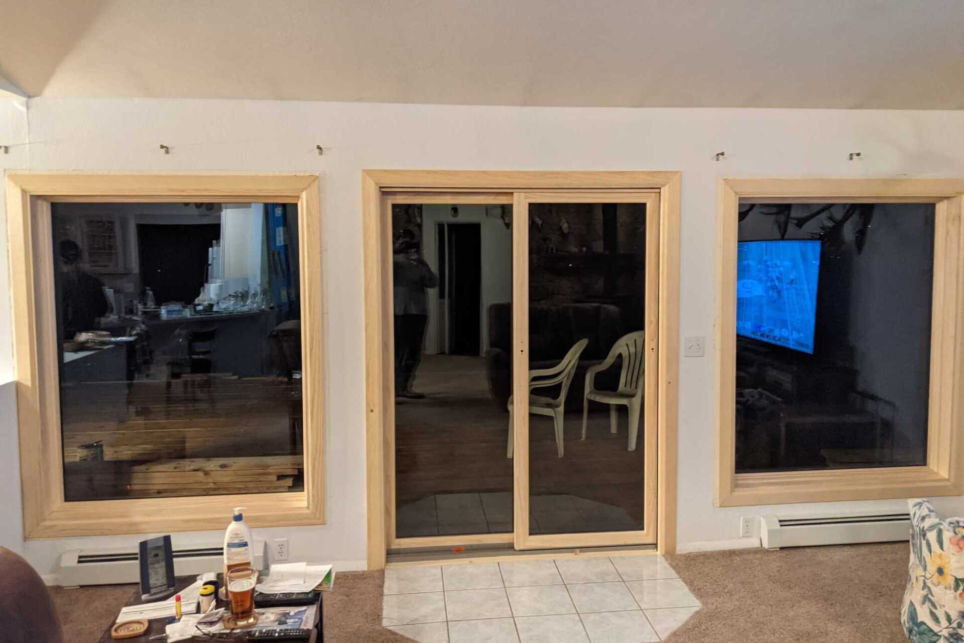 A living room with a lot of windows and sliding glass doors.
