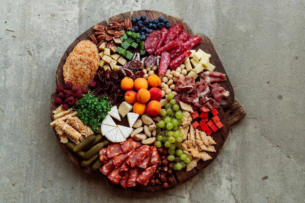 A wooden cutting board filled with lots of different types of food.