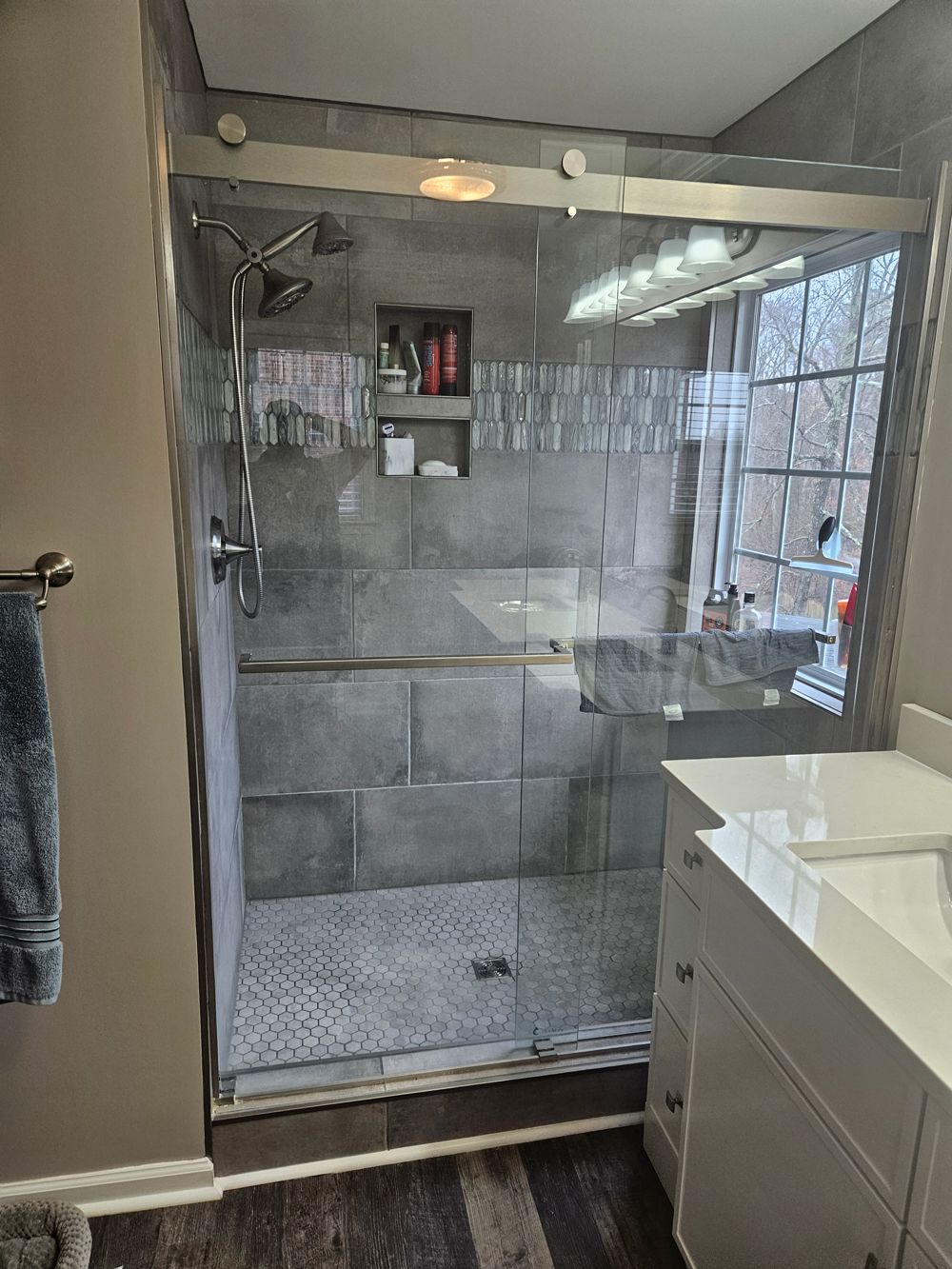 A bathroom with a sliding glass shower door and a sink.