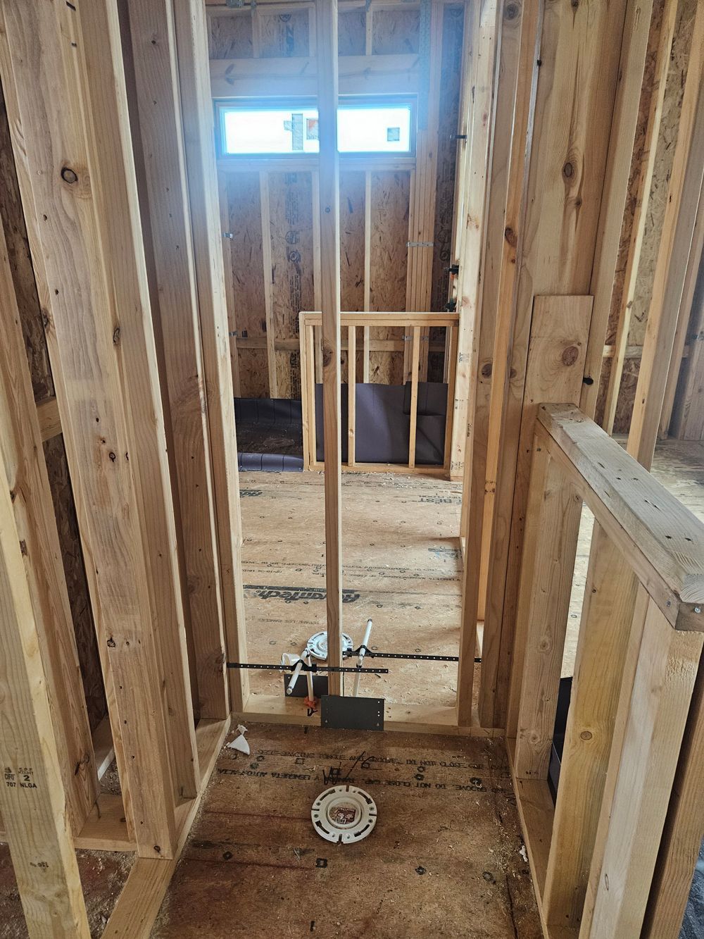 A bathroom under construction in a house with wooden walls and a toilet.