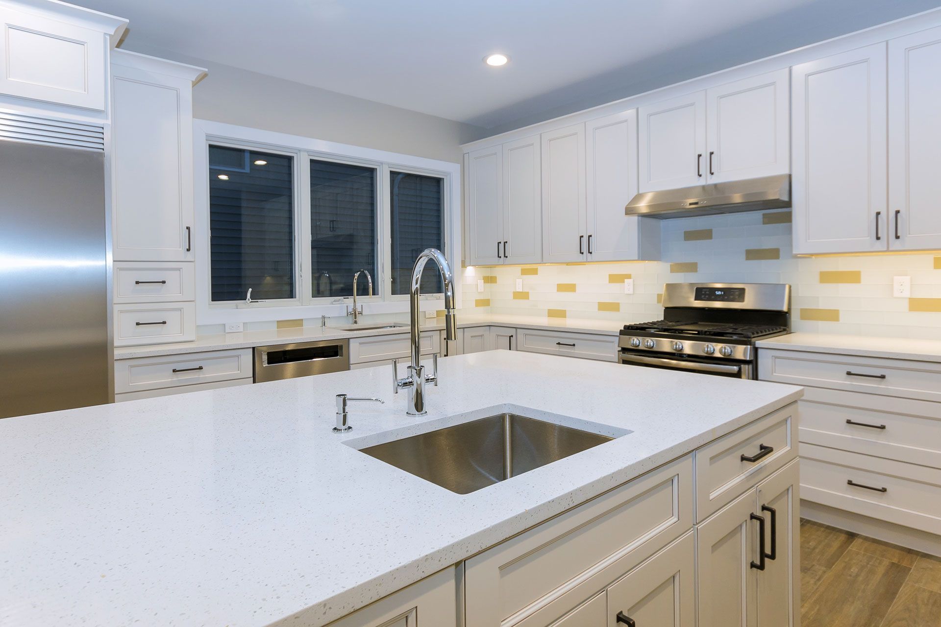 A kitchen with white cabinets , stainless steel appliances , and a sink.