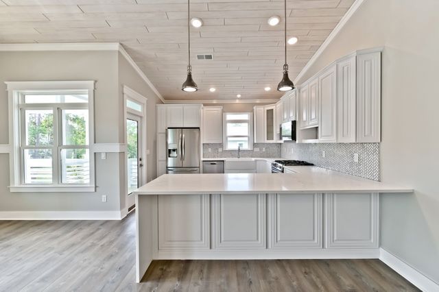 A kitchen with white cabinets and stainless steel appliances