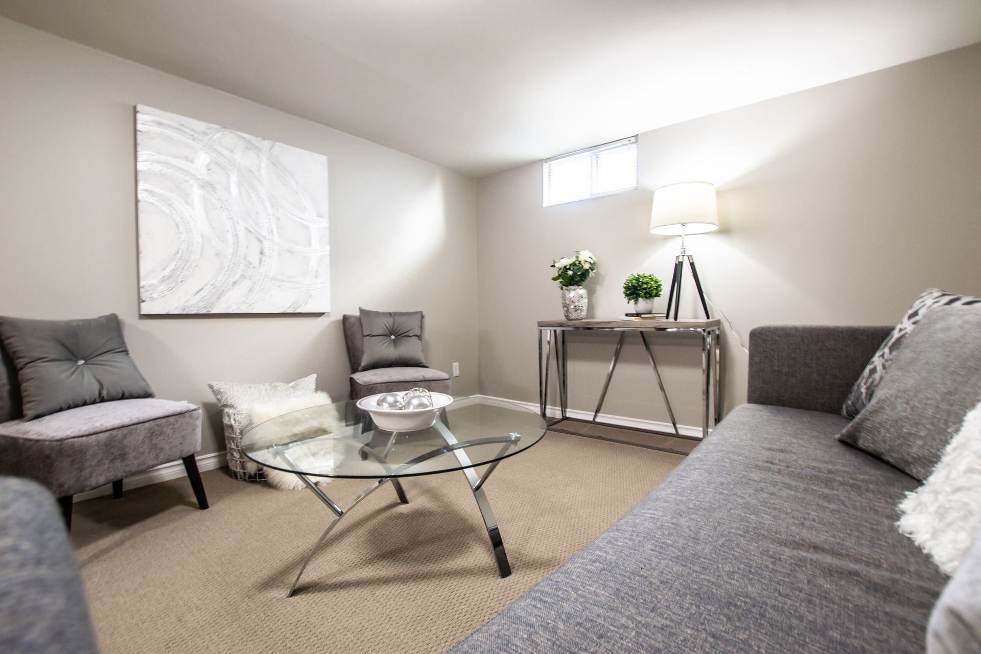 A living room with a couch , chairs , and a coffee table.