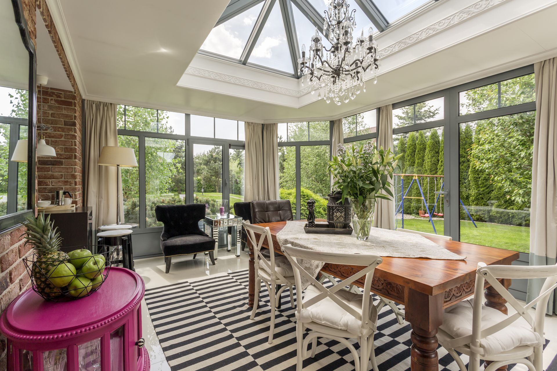 A dining room with a table and chairs and a skylight.