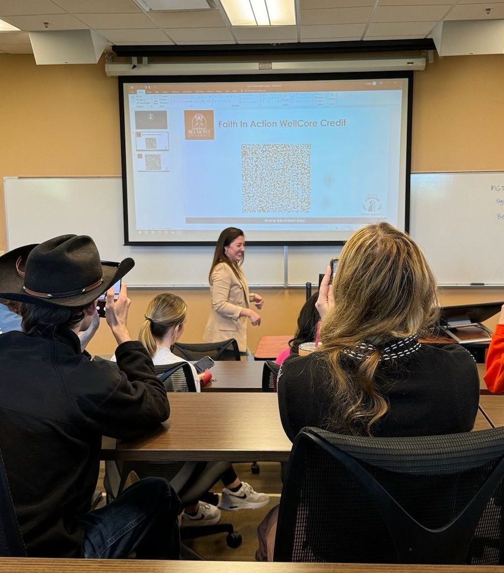 A woman is giving a presentation to a group of people in a classroom.