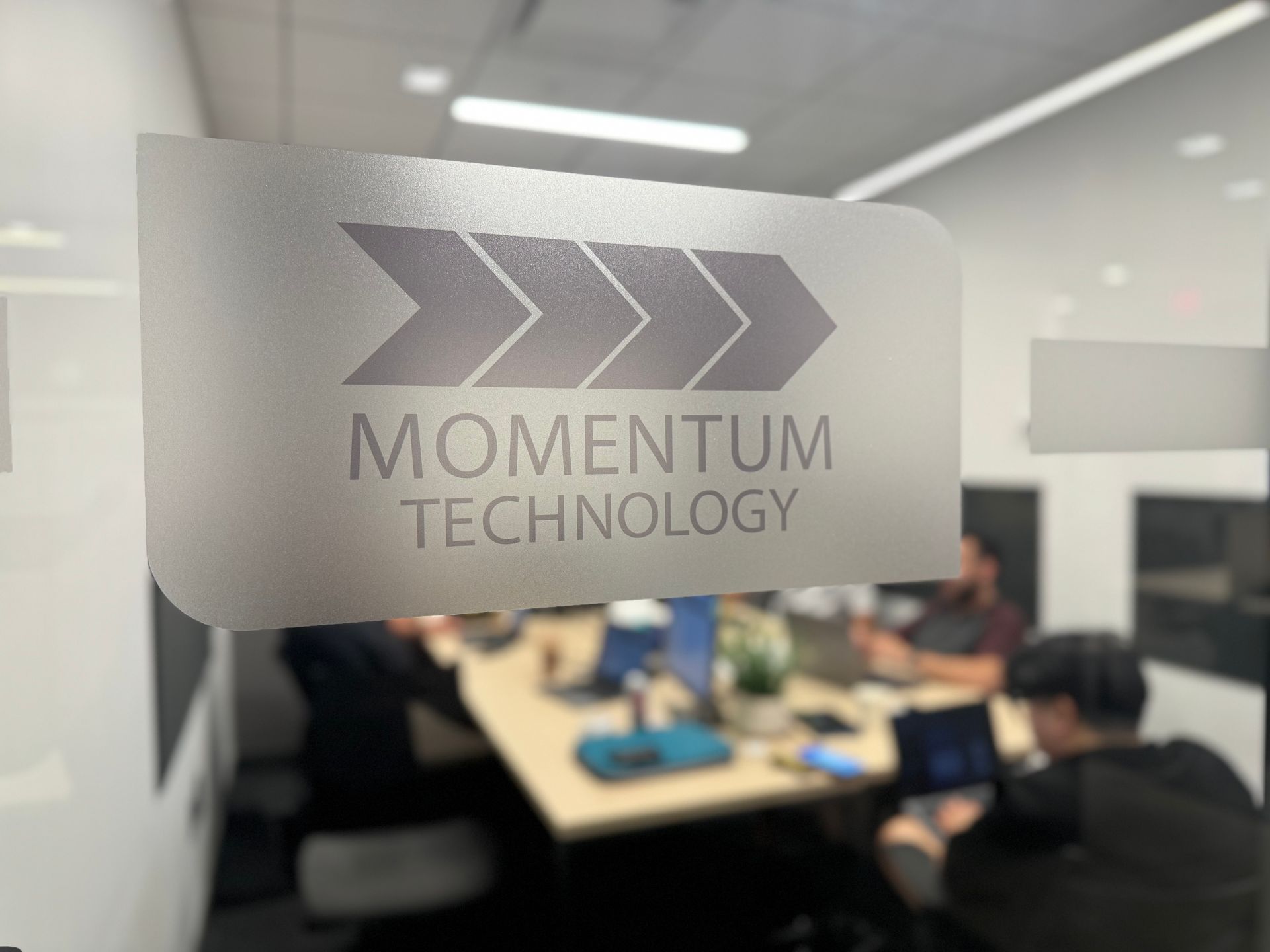 A momentum technology logo is on a glass door