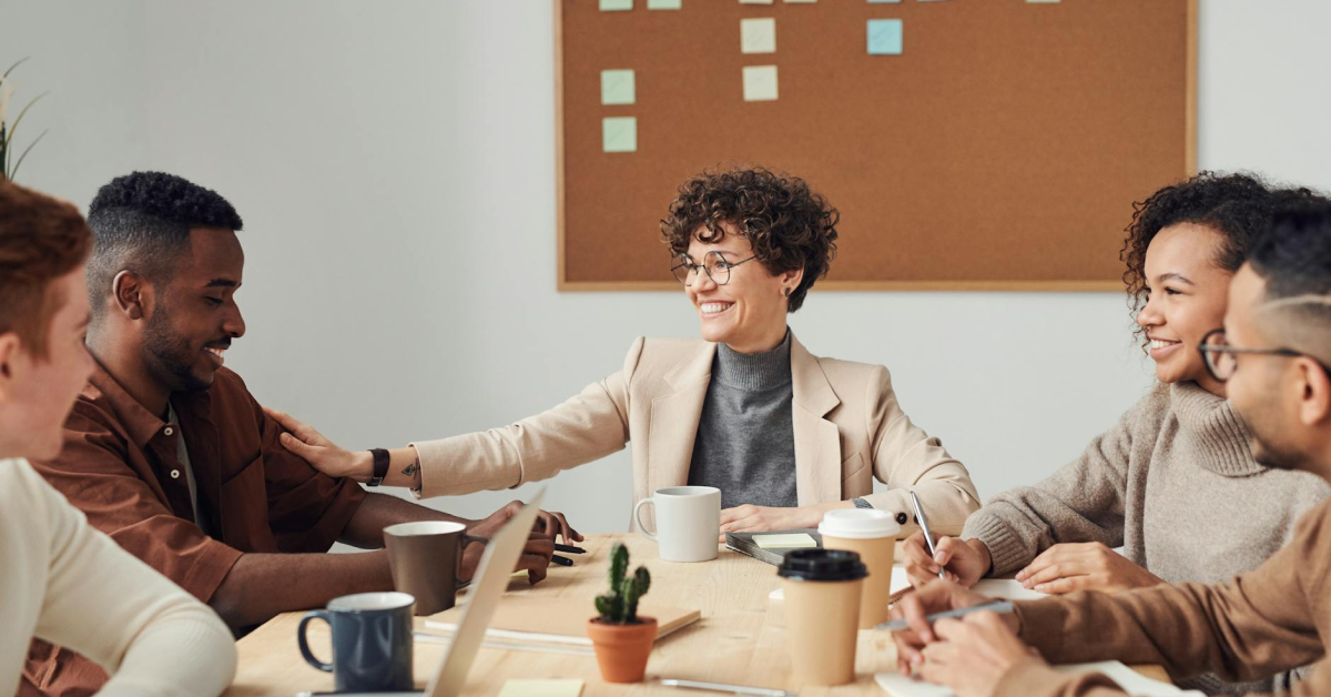 A group of people are sitting around a table having a meeting.