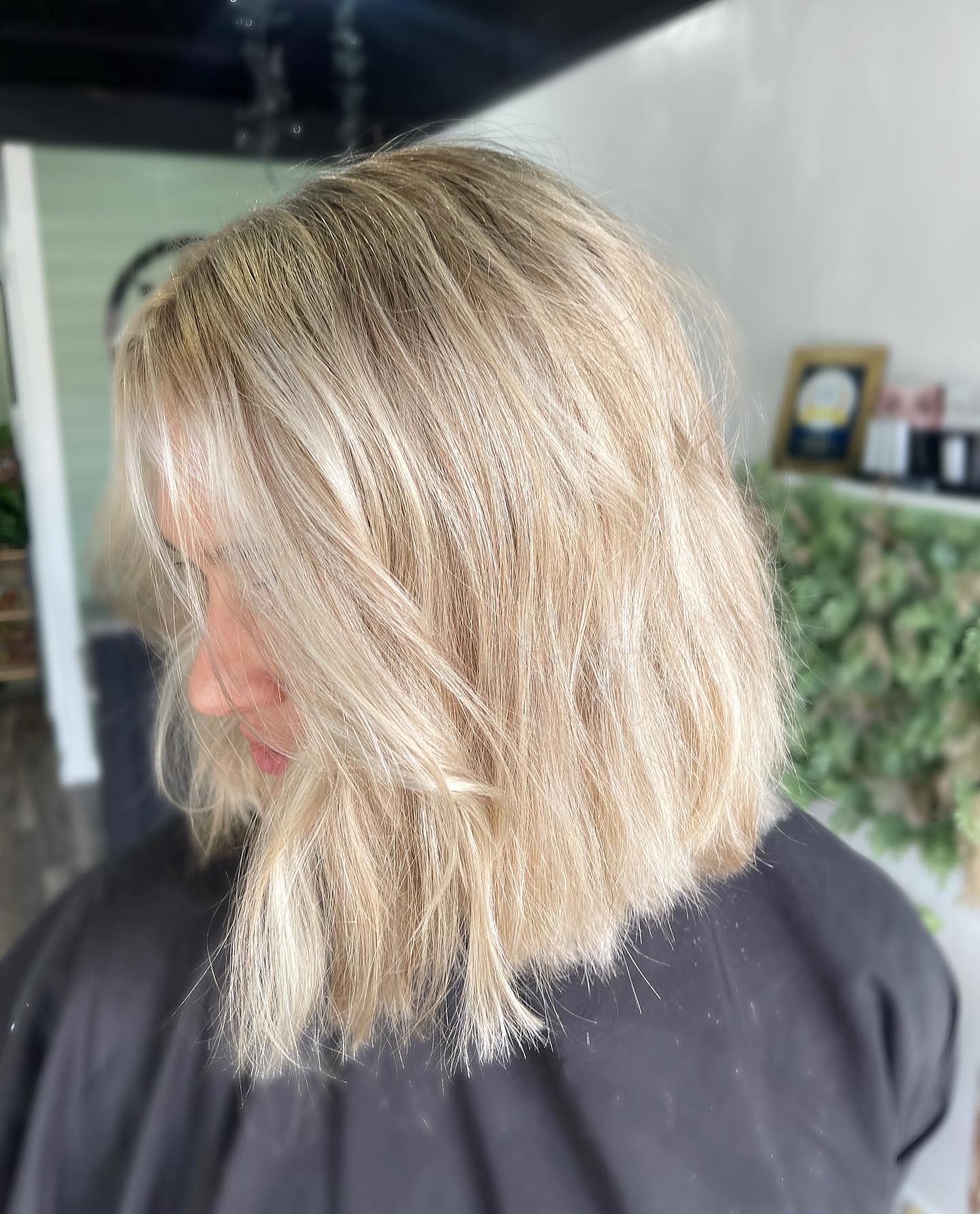 Blonde, layered bob haircut; salon setting.