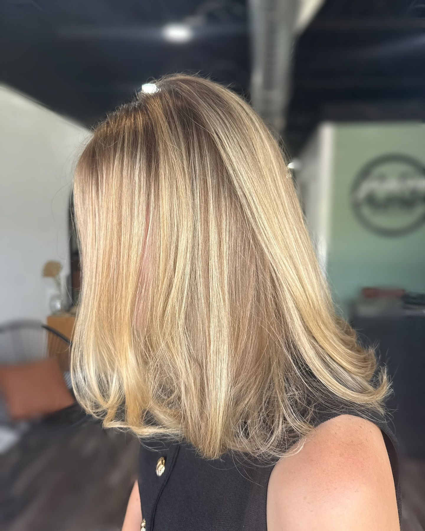 Blonde hair with highlights, shoulder-length, in a salon setting.