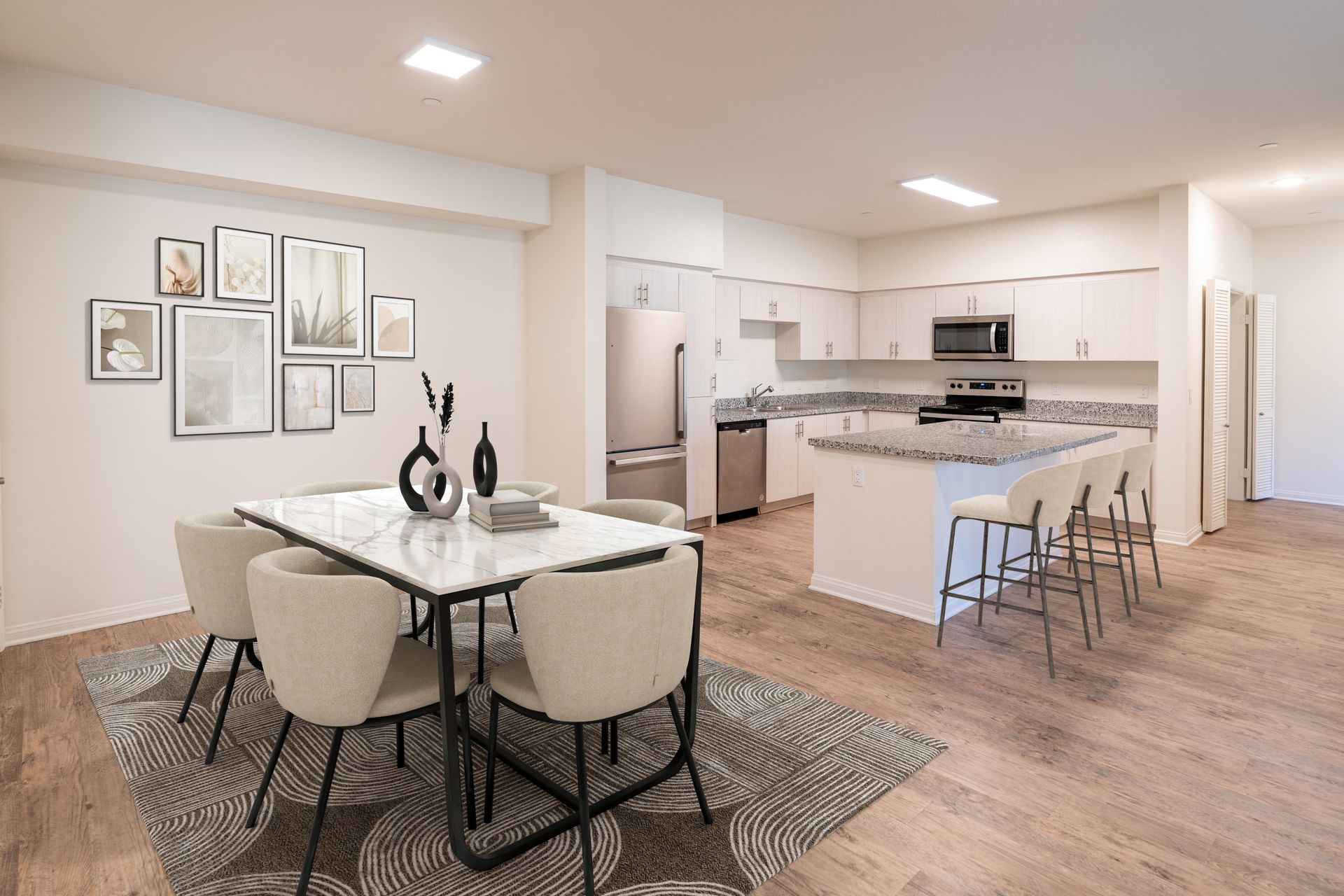 A kitchen with a center island and stainless steel appliances and dinning room table