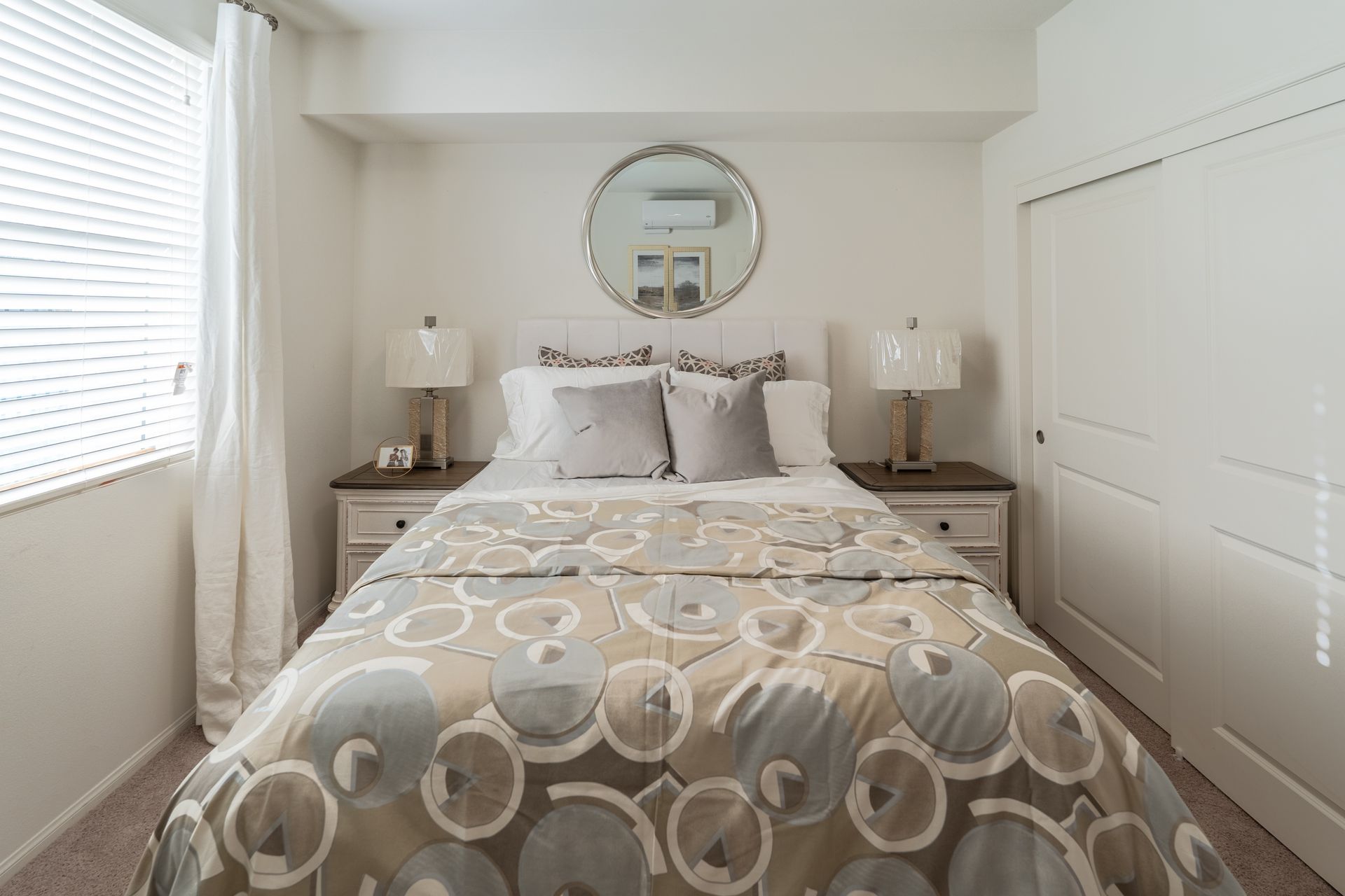 A bed room with a bed and night stands on each side of the bed