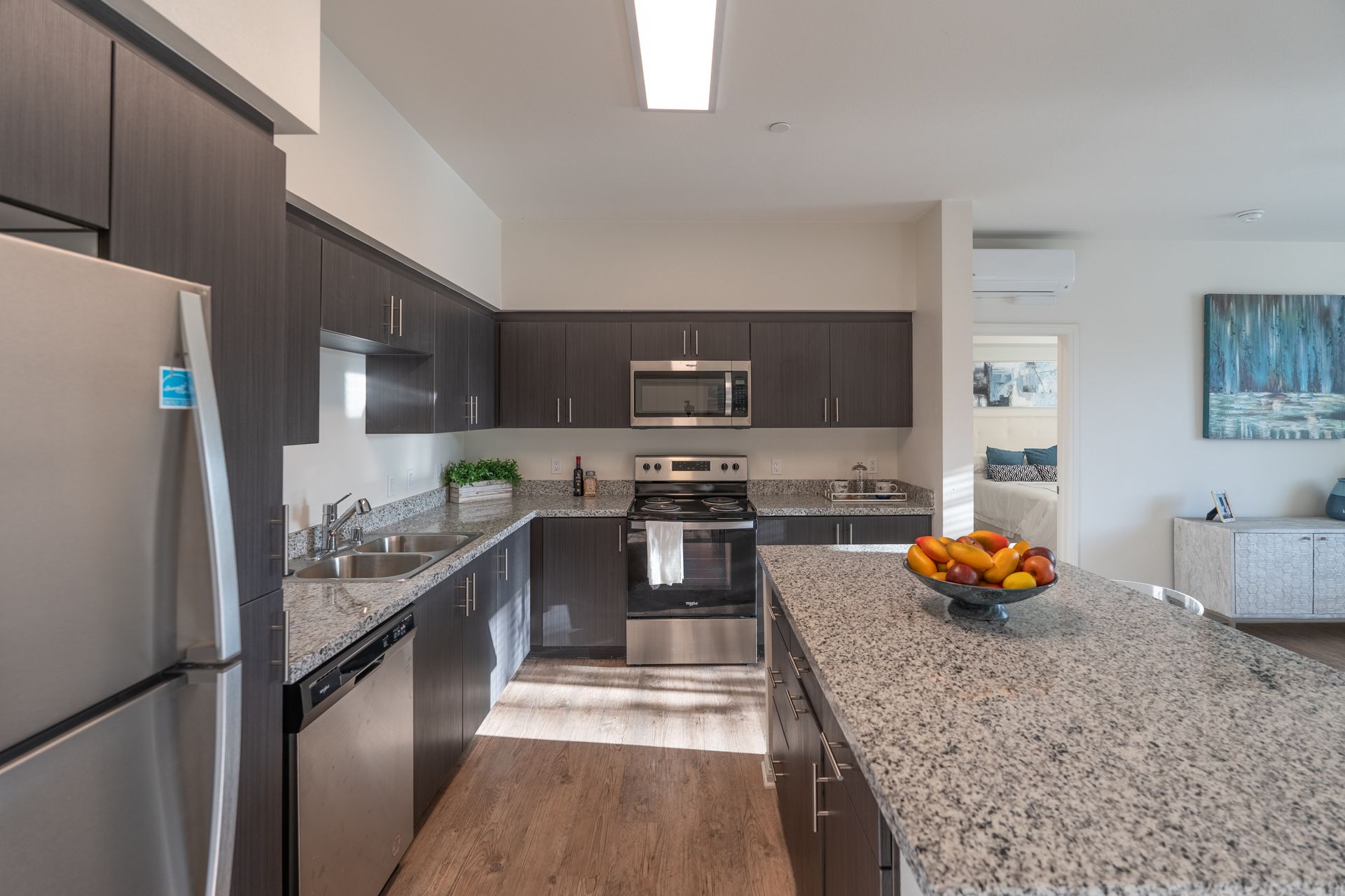 A kitchen with a center island and stainless steel appliances
