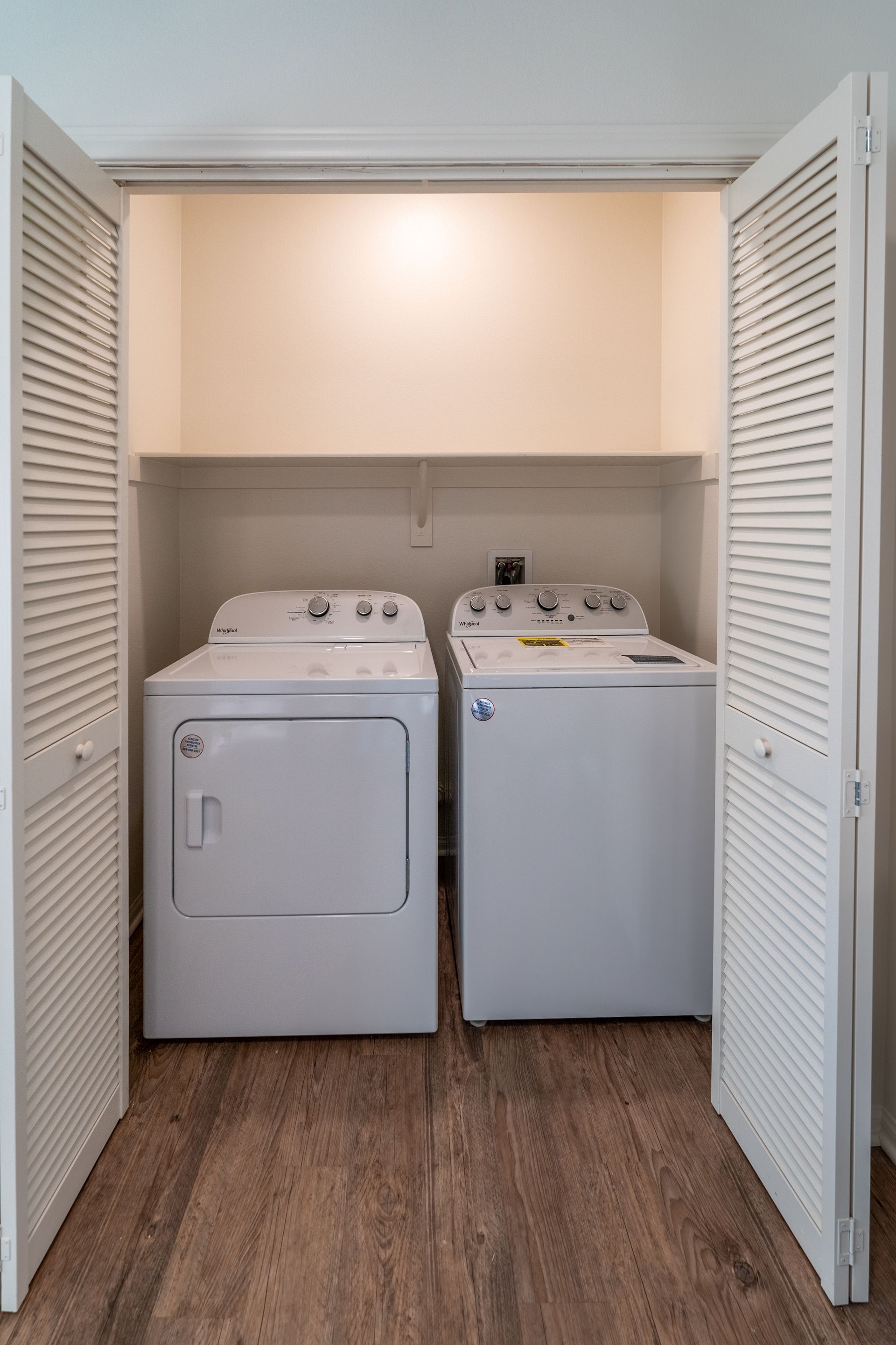 A washroom closet with door open and Washer and dryer inside 