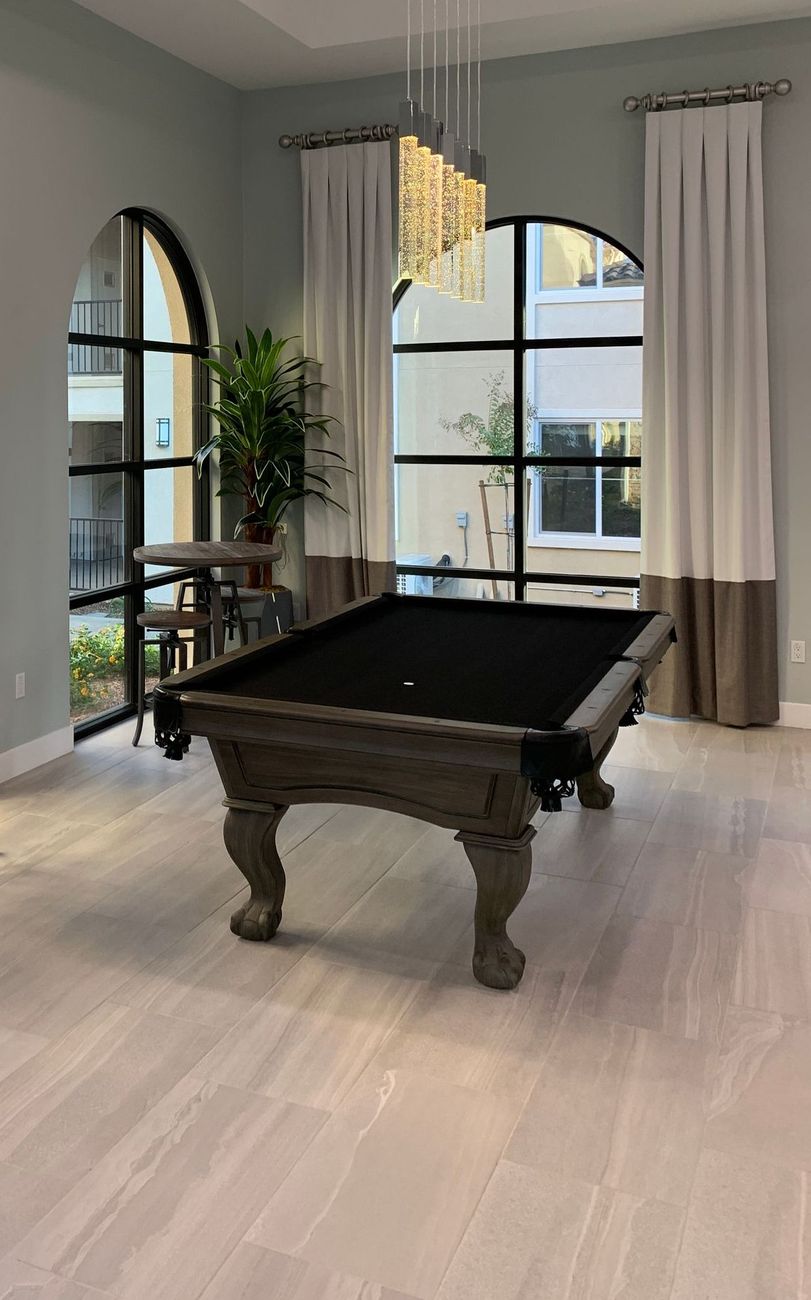there is a pool table in the middle of the room .