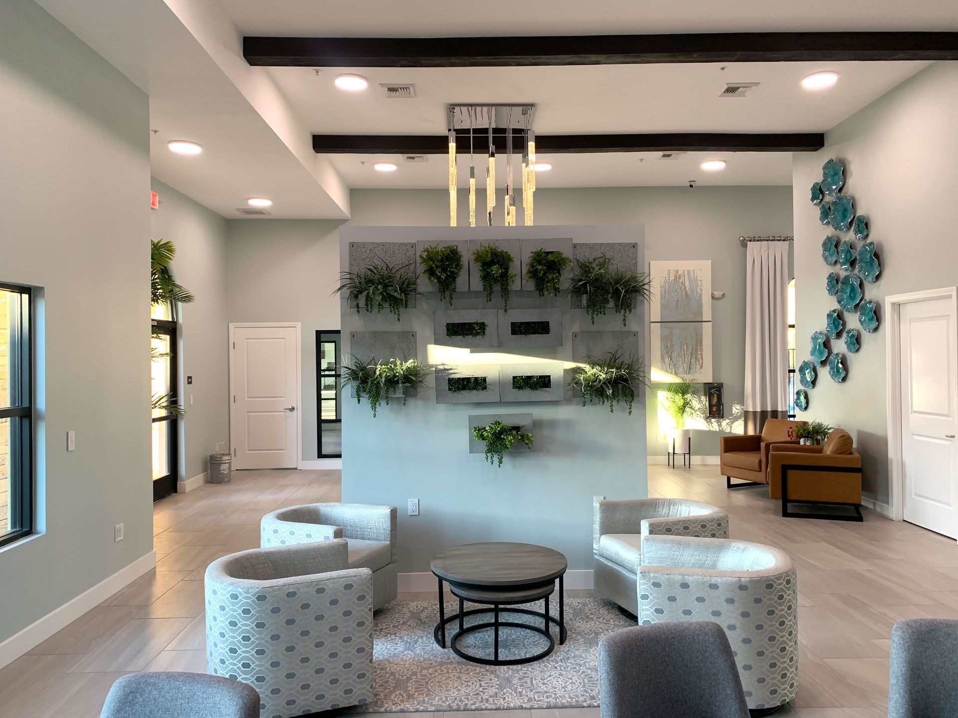 a living room with chairs , a table and a chandelier .