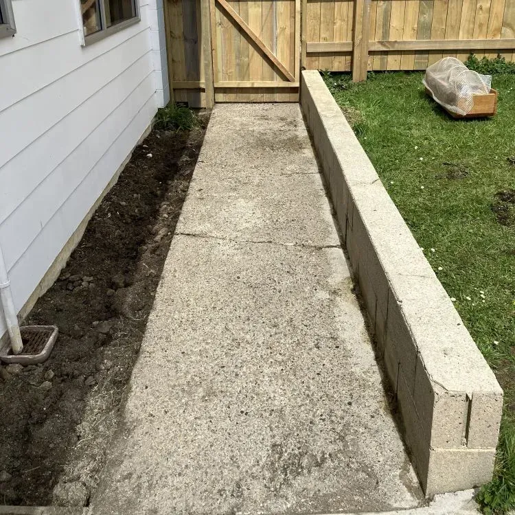 After: completed water blasting job for a concrete path and retaining wall for a residential customer in Bradford.