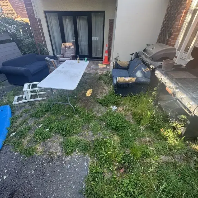 Before: Courtyard with overgrown grass and weeds in Opoho, Dunedin.