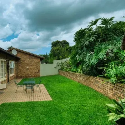 Dunedin lawn and boundary under grey seasonal clouds, showing climate impact on section clearing recovery.