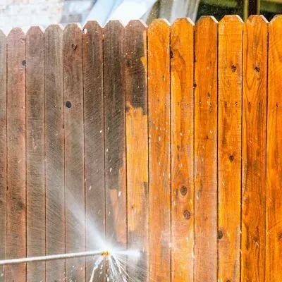 Pressure washing a wooden fence to wash away dirt and refresh the timber surface in Glenross, Dunedin.
