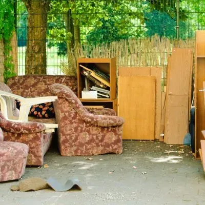 Old household furniture and unwanted items are ready for removal in Taieri, Dunedin.