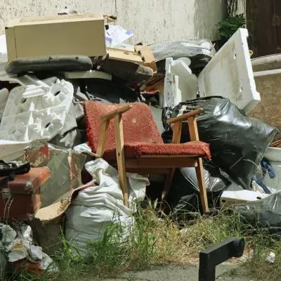 Household waste buildup in a Dunedin backyard shows cluttered conditions and an unmanaged rubbish impact.