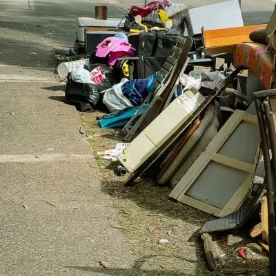 Household rubbish dumped on the roadside in Dunedin shows illegal dumping and improper waste disposal.