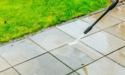 Pressure washing a paver patio to remove dirt and grime during an exterior clean in St Clair, Dunedin.